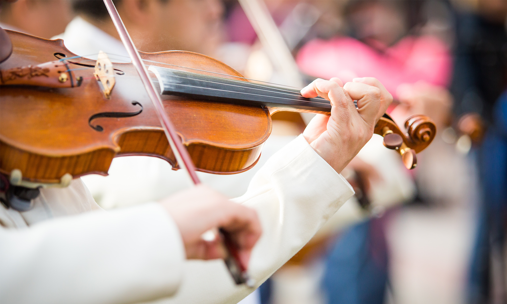 Close-up image of violinist's hand and violin in play.