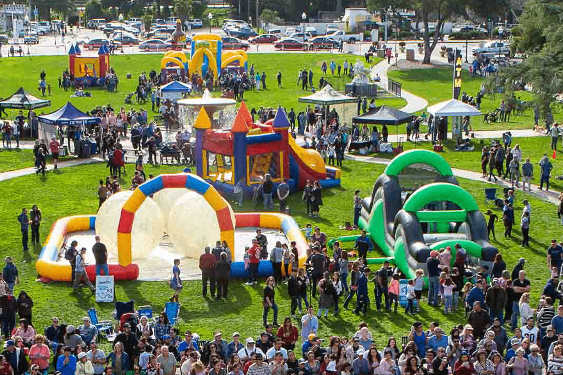 Image of blowup bounce houses and similar fun activities in Atascadero's Sunken Gardens during a past Tamale Festival.